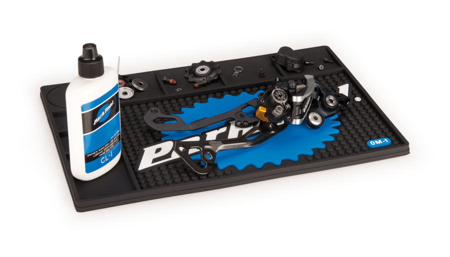 Park Tool OM-1 com ferramentas e peças dispostas sobre o tapete