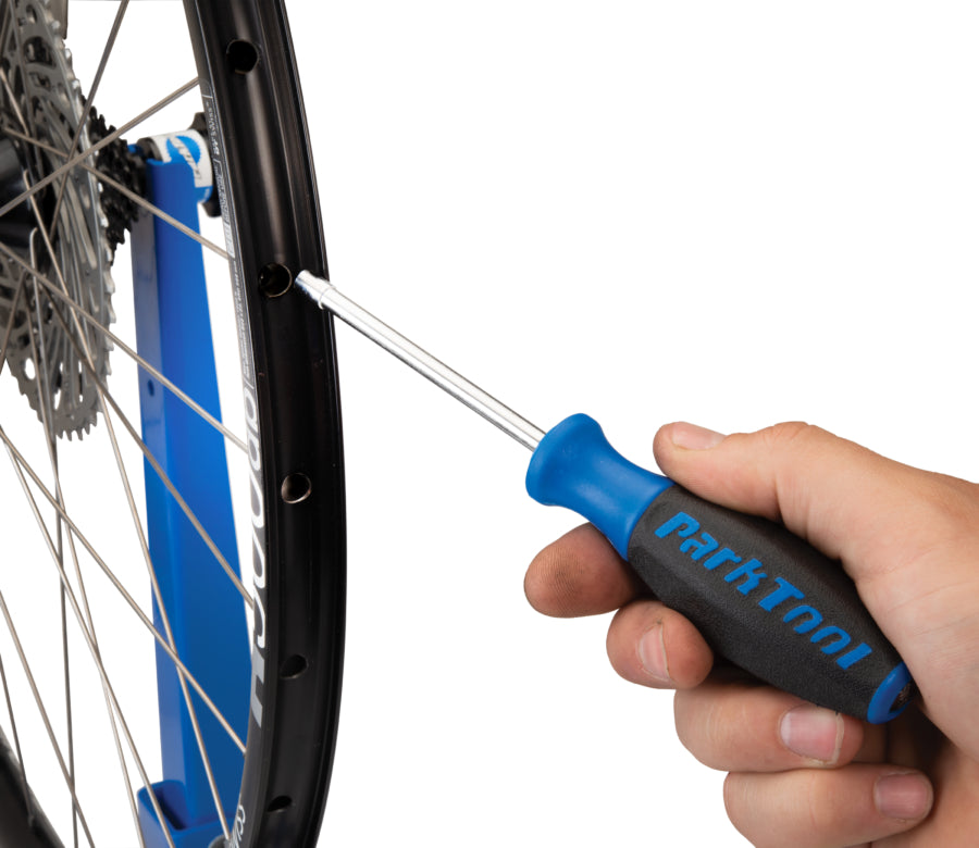 Park Tool SW-17 inserida no aro para alcançar uma porca de raio interna