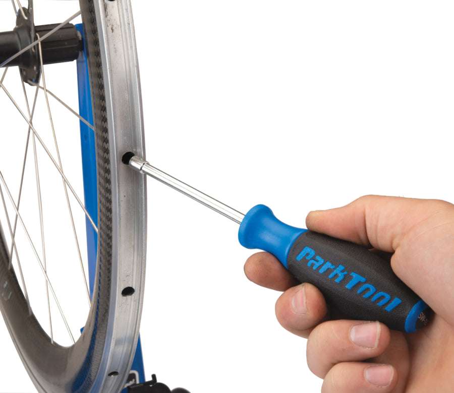 Park Tool SW-19 inserida no aro para alcançar uma porca de raio interna